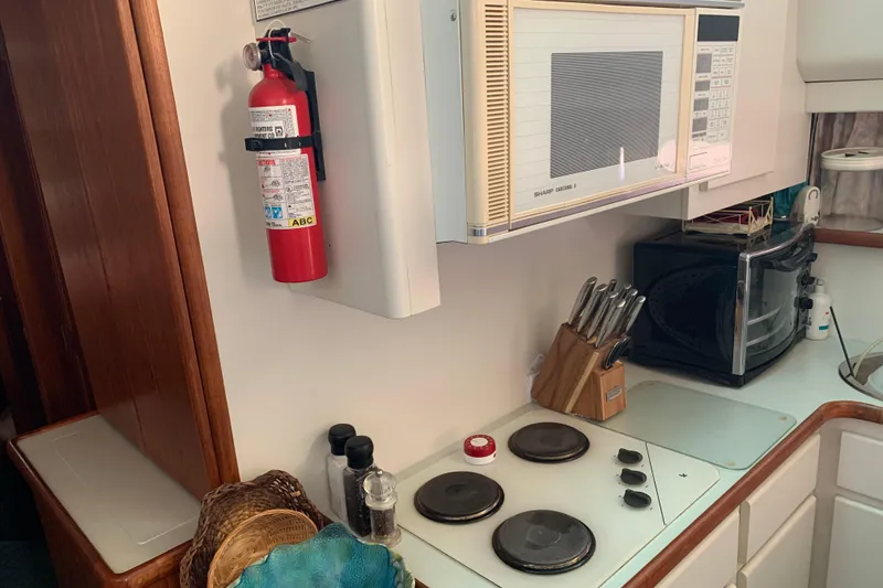 Slide: The Image of 1994 Carver 440 Aft Cabin Motor Yacht kitchen with microwave, stove, and fire extinguisher. - 20