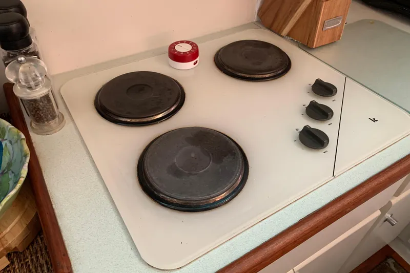 Slide: The Image of Electric stove with three burners and control knobs on a 1994 Carver 440 Aft Cabin Motor Yacht. - 22