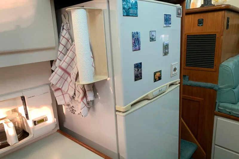 Slide: The Image of 1994 Carver 440 Aft Cabin Motor Yacht kitchen with fridge, magnets, and paper towel holder. - 23