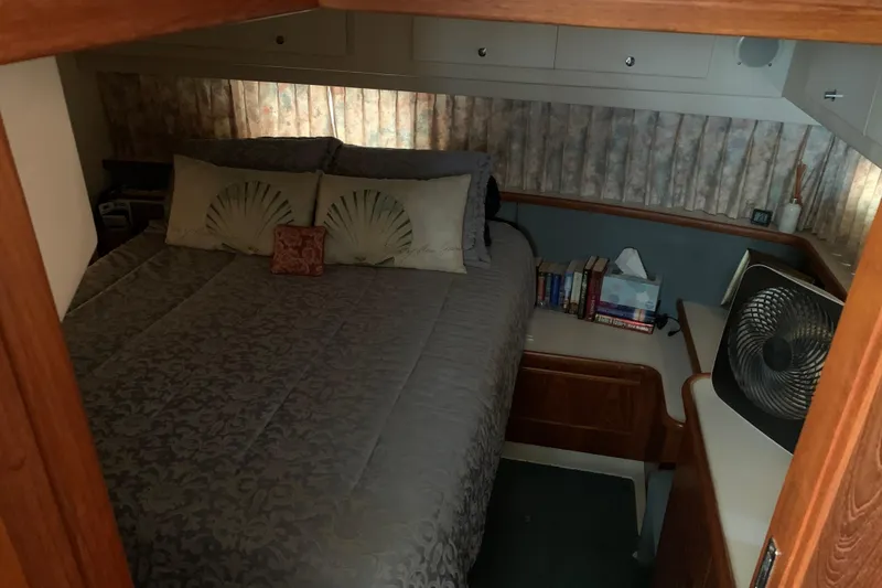 Slide: The Image of Cozy bedroom in 1994 Carver 440 Aft Cabin Motor Yacht with books and fan. - 28