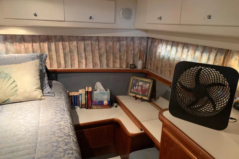 Slide: The Image of Cozy cabin interior of 1994 Carver 440 Aft Cabin Motor Yacht with books and fan. - 32