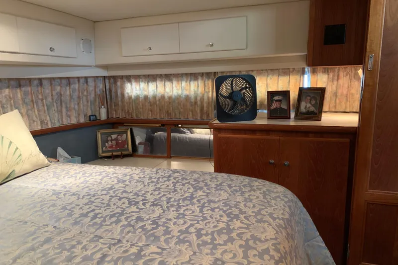 Slide: The Image of Cozy bedroom in 1994 Carver 440 Aft Cabin Motor Yacht with decorative bedding and personal photos. - 33
