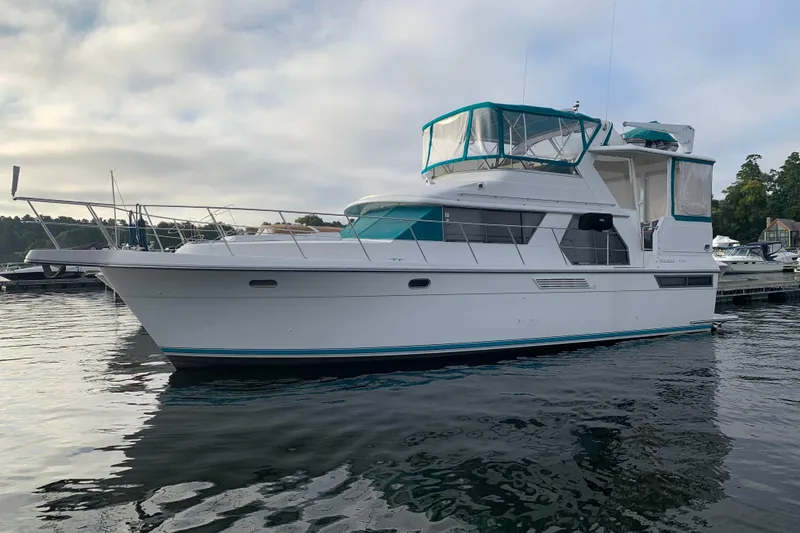 Slide: The Image of 1994 Carver 440 Aft Cabin Motor Yacht docked on calm water. - 40