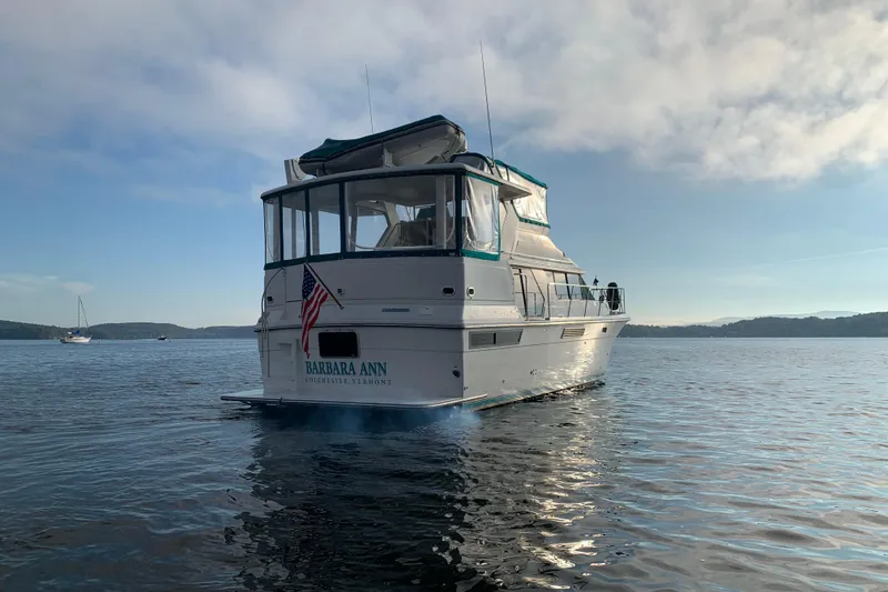 Slide: The Image of 1994 Carver 440 Aft Cabin Motor Yacht on serene water, rear view. - 42