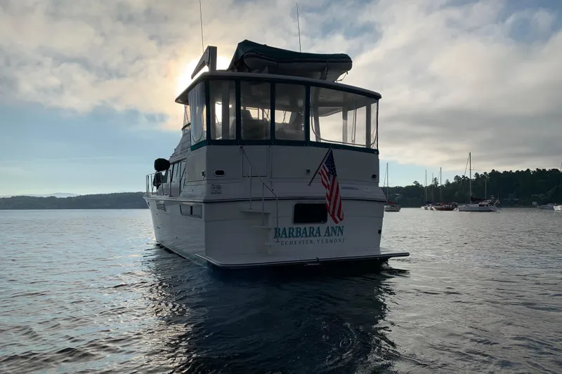 Slide: The Image of 1994 Carver 440 Aft Cabin Motor Yacht on serene water at sunset. - 44