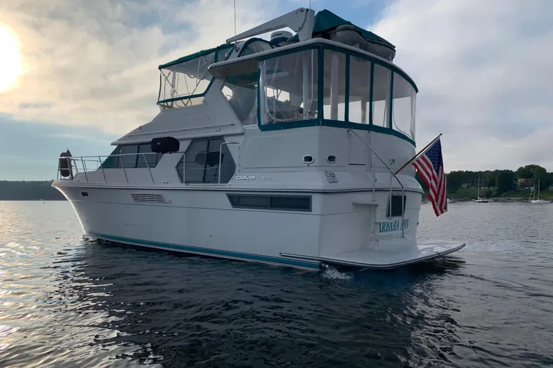 Slide: The Image of 1994 Carver 440 Aft Cabin Motor Yacht on calm water at sunset. - 46