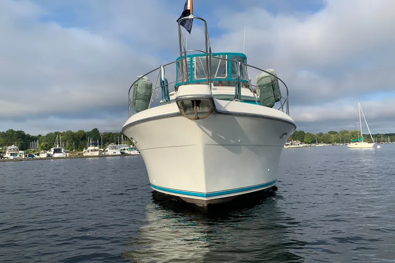 Slide: The Image of 1994 Carver 440 Aft Cabin Motor Yacht on calm water, with marina background. - 50