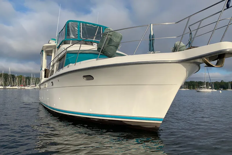 Slide: The Image of 1994 Carver 440 Aft Cabin Motor Yacht on calm water, featuring sleek design and spacious deck. - 51