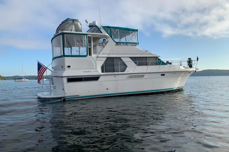 Slide: The Image of 1994 Carver 440 Aft Cabin Motor Yacht on calm water, featuring a sleek design. - 55
