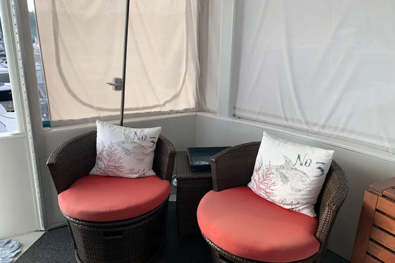 Slide: The Image of Cozy seating area on 1994 Carver 440 Aft Cabin Motor Yacht with wicker chairs and decorative pillows. - 7