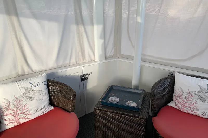 Slide: The Image of Cozy seating area on 1994 Carver 440 Aft Cabin Motor Yacht with wicker chairs and decorative pillows. - 8