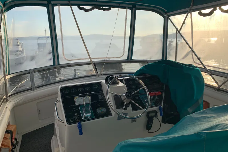 Slide: The Image of 1994 Carver 440 Aft Cabin Motor Yacht helm with scenic marina view. - 9