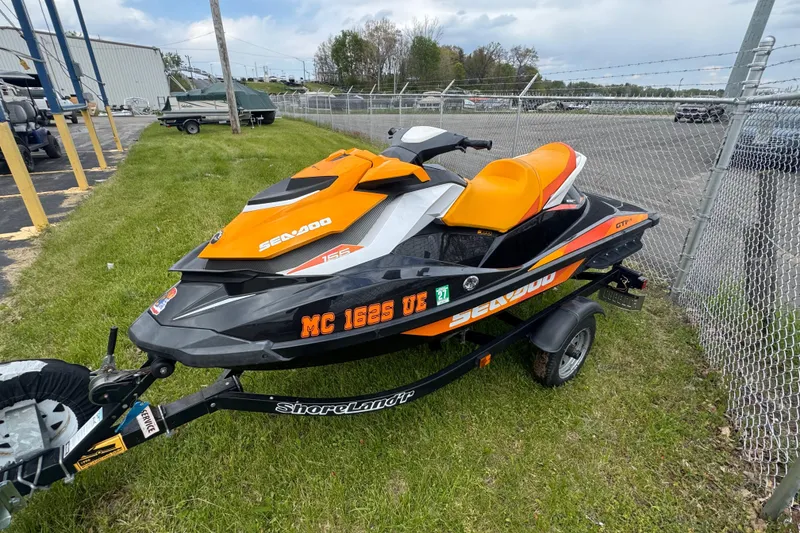 Slide: The Image of 2018 Sea-Doo GTI SE 155 jet ski on trailer, parked near a fence. - 8