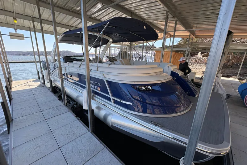 The Image of 2023 Bennington QX 30 QXFBWA X2 Wide Beam pontoon boat docked under a canopy. - 0