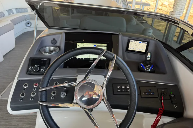 Slide: The Image of 2023 Bennington QX 30 boat dashboard with steering wheel and control panels. - 10