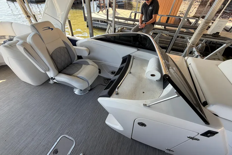 Slide: The Image of 2023 Bennington QX 30 boat interior with helm seat and dashboard view. - 24