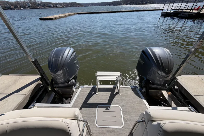 Slide: The Image of 2023 Bennington QX 30 pontoon boat with dual Yamaha outboard motors on a lake. - 28