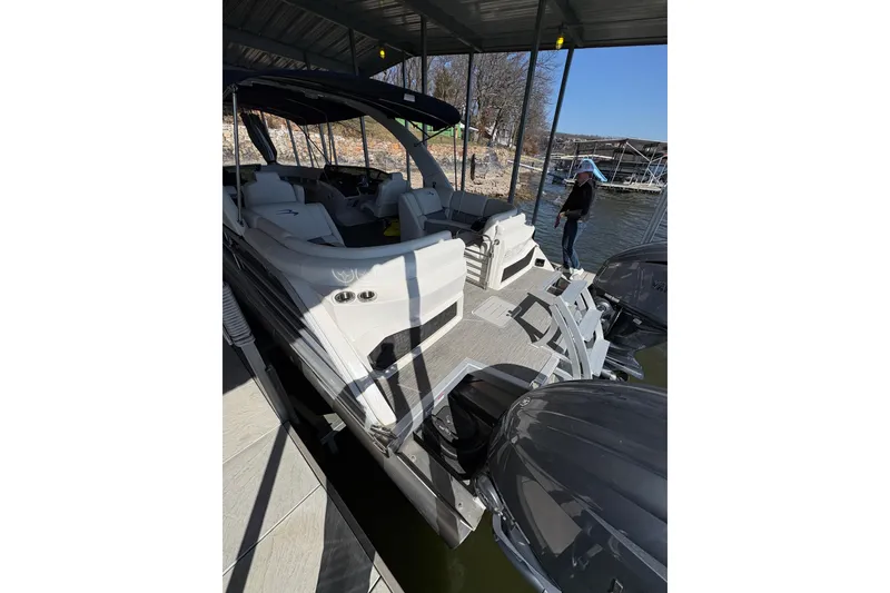 Slide: The Image of 2023 Bennington QX 30 QXFBWA X2 Wide Beam pontoon boat docked under a canopy. - 31