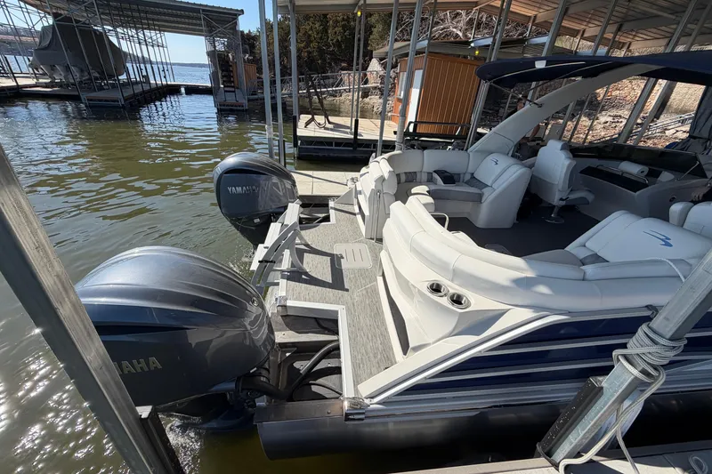 Slide: The Image of 2023 Bennington QX 30 pontoon boat docked, featuring Yamaha engines and luxurious seating. - 4