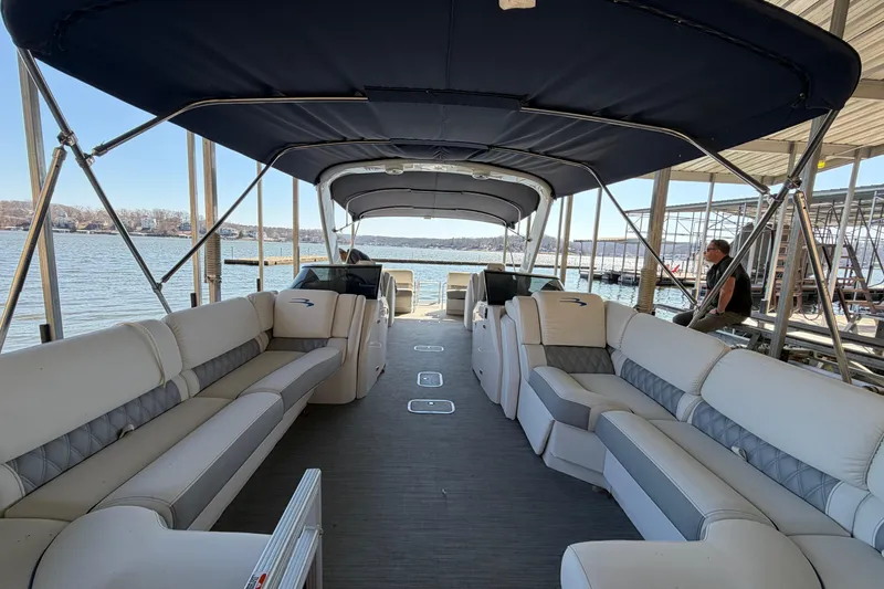 Slide: The Image of 2023 Bennington QX 30 pontoon boat interior with spacious seating and canopy on a lake. - 5