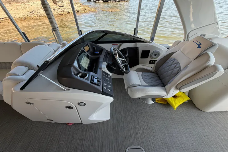 Slide: The Image of 2023 Bennington QX 30 boat interior with helm, steering wheel, and luxurious seating. - 6