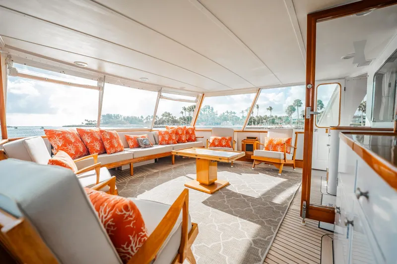 Slide: The Image of Luxurious 1972 Trumpy 72 Motor Yacht interior with vibrant orange cushions and panoramic windows. - 12