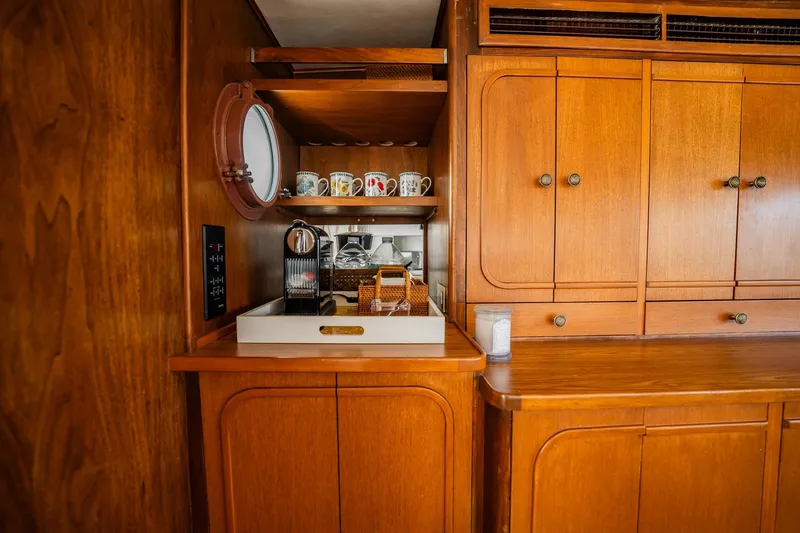 Slide: The Image of Vintage 1972 Trumpy 72 Motor Yacht interior with wooden cabinetry and coffee station. - 19