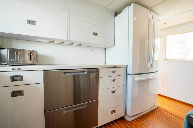 Slide: The Image of Modern kitchen in a 1972 Trumpy 72 Motor Yacht with sleek appliances and wooden flooring. - 23