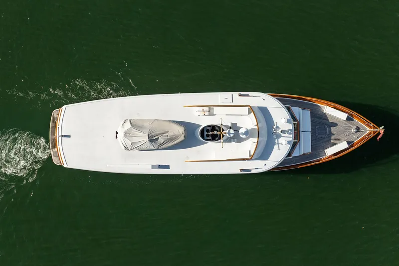 Slide: The Image of Aerial view of 1972 Trumpy 72 Motor Yacht cruising on green water. - 9