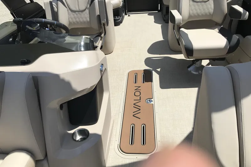 Slide: The Image of Interior of 2026 Avalon LSZ Quad Lounge Tri Log boat with beige seating and steering area. - 15