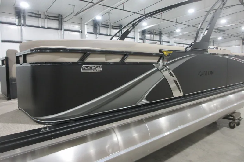 Slide: The Image of 2026 Avalon LSZ Quad Lounge Tri Log pontoon boat in a showroom. - 2