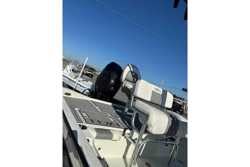 Slide: The Image of 2026 Excel 230 Bay Pro Elite boat with seating and motor, under clear blue sky. - 12
