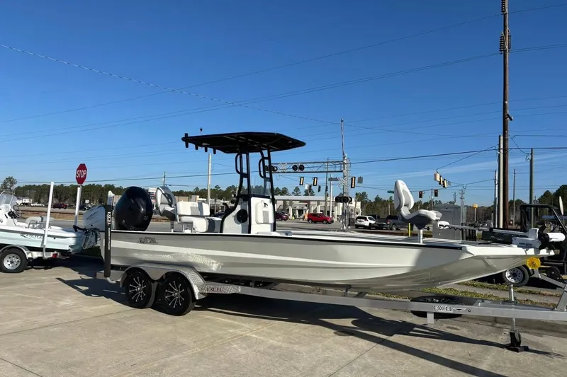 The Image of 2026 Excel 230 Bay Pro Elite boat on trailer, parked outdoors under clear blue sky. - 6