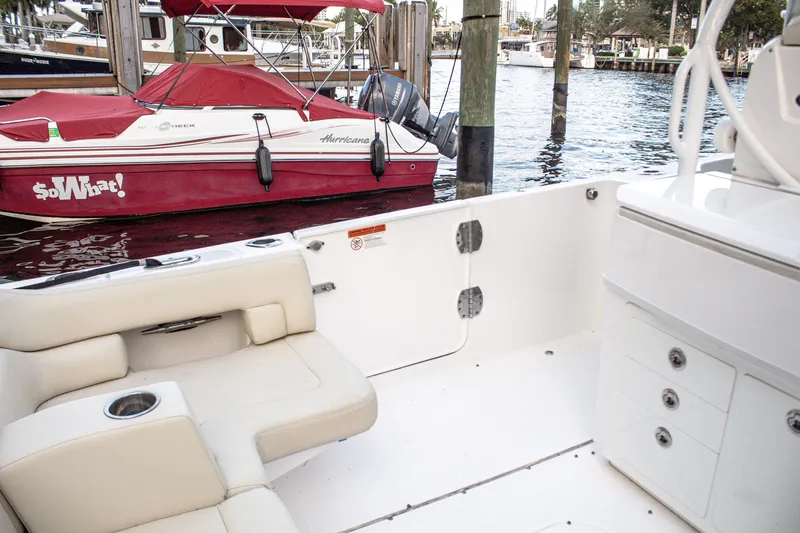 Slide: The Image of 2017 Everglades 360 LXC boat interior with seating, docked near a red boat. - 15