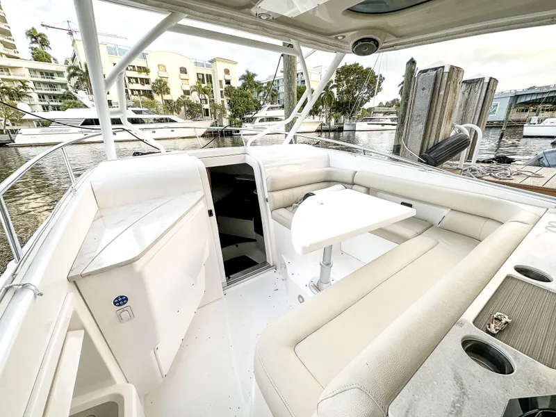 Slide: The Image of 2017 Everglades 360 LXC boat interior with seating and table, docked at marina. - 19