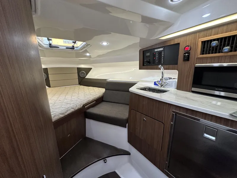 Slide: The Image of 2017 Everglades 360 LXC cabin interior with bed, kitchenette, and modern amenities. - 23