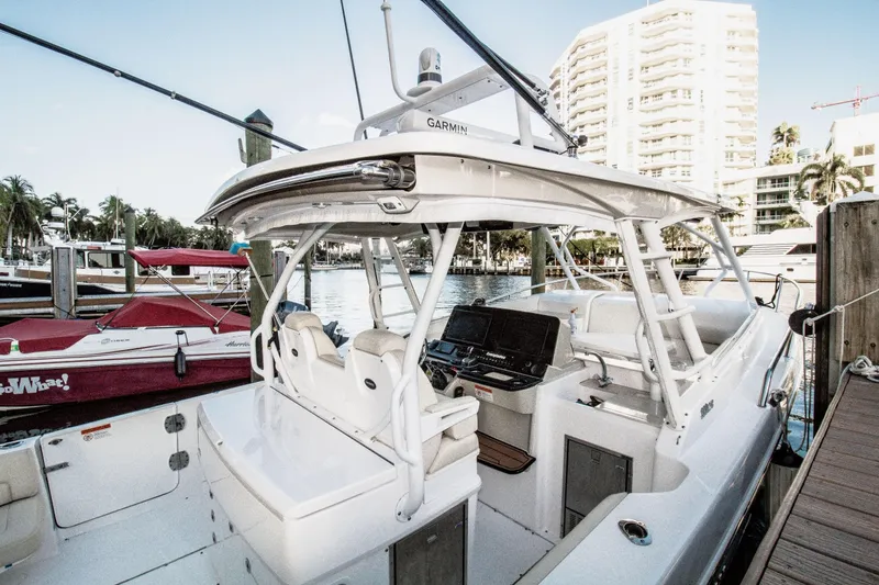 Slide: The Image of 2017 Everglades 360 LXC boat docked at marina with modern interior and navigation equipment. - 6