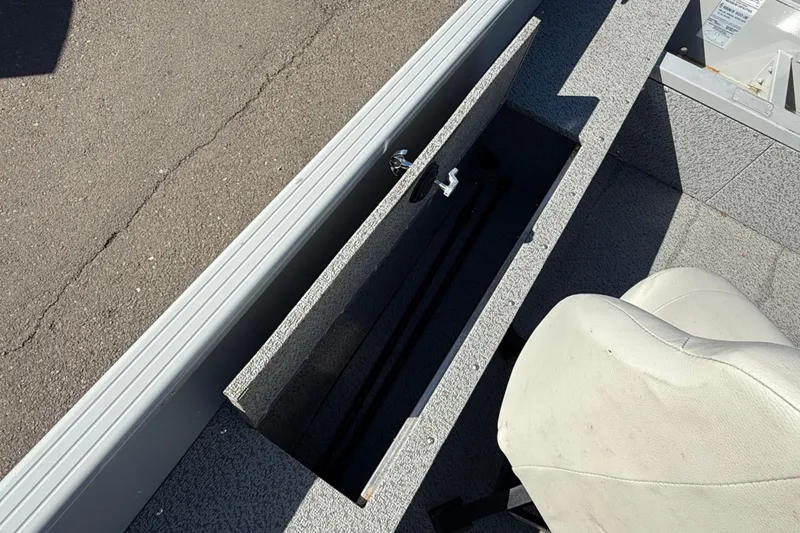 Slide: The Image of 2022 Smoker Craft Freedom 160 SC boat interior with open storage compartment and seat. - 11