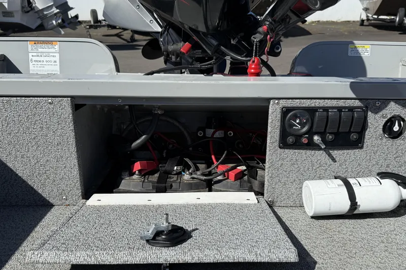 Slide: The Image of 2022 Smoker Craft Freedom 160 SC boat battery compartment with control panel and fire extinguisher. - 13