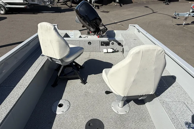 Slide: The Image of 2022 Smoker Craft Freedom 160 SC boat interior with two white seats and motor. - 9