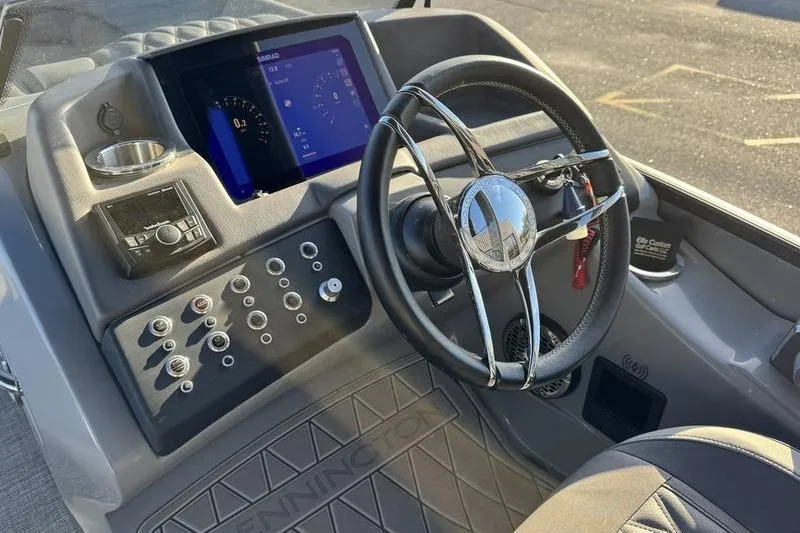 Slide: The Image of 2024 Bennington 25 QXSBA boat dashboard with steering wheel and control panel. - 15