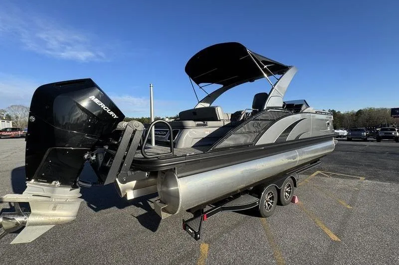 Slide: The Image of 2024 Bennington 25 QXSBA pontoon boat on trailer with Mercury outboard motor. - 4
