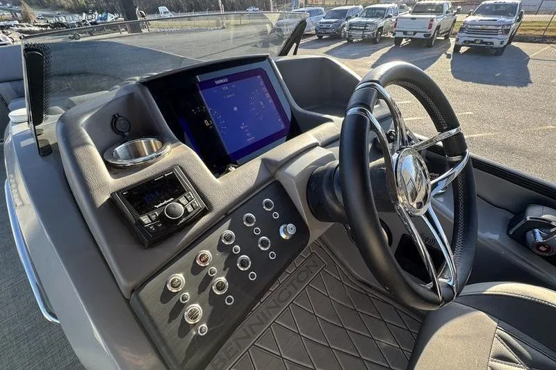 Slide: The Image of 2024 Bennington 25 QXSBA boat dashboard with steering wheel and control panel. - 7