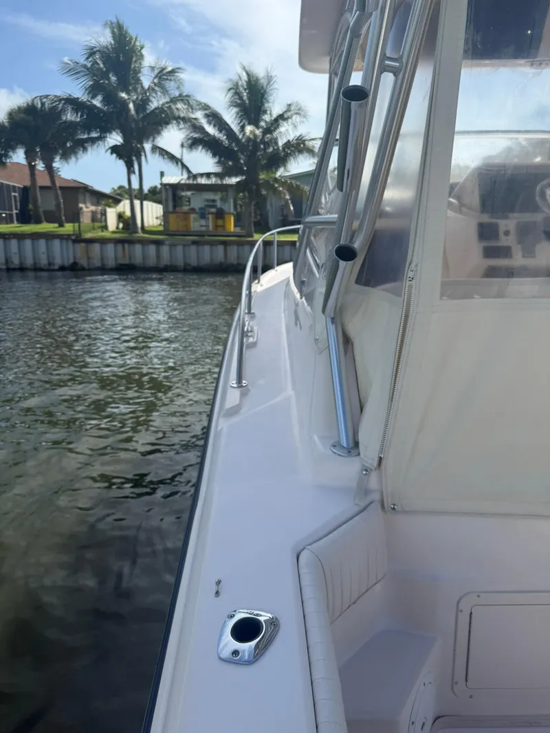 Slide: The Image of 2007 Grady-White Express 330 boat docked near palm trees and waterfront homes. - 20