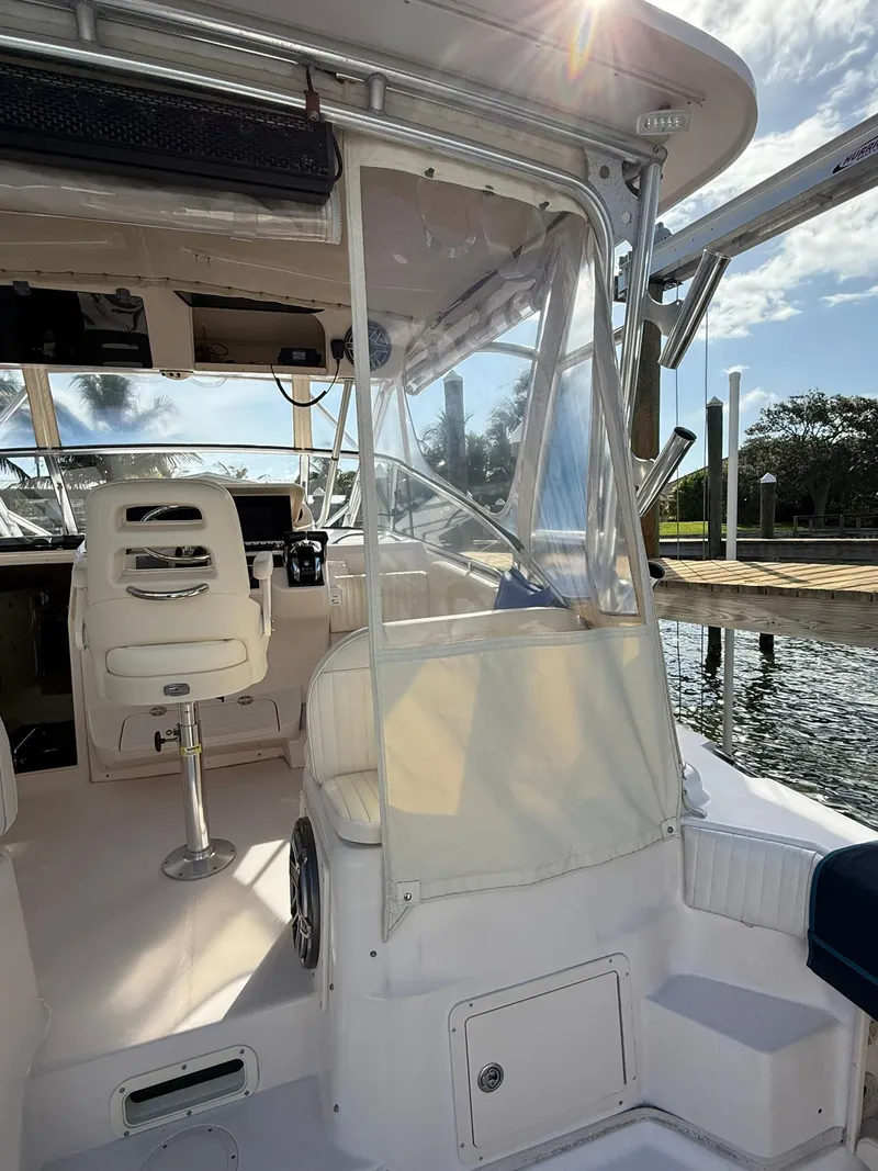 Slide: The Image of 2007 Grady-White Express 330 boat interior with helm and seating, docked by the water. - 28