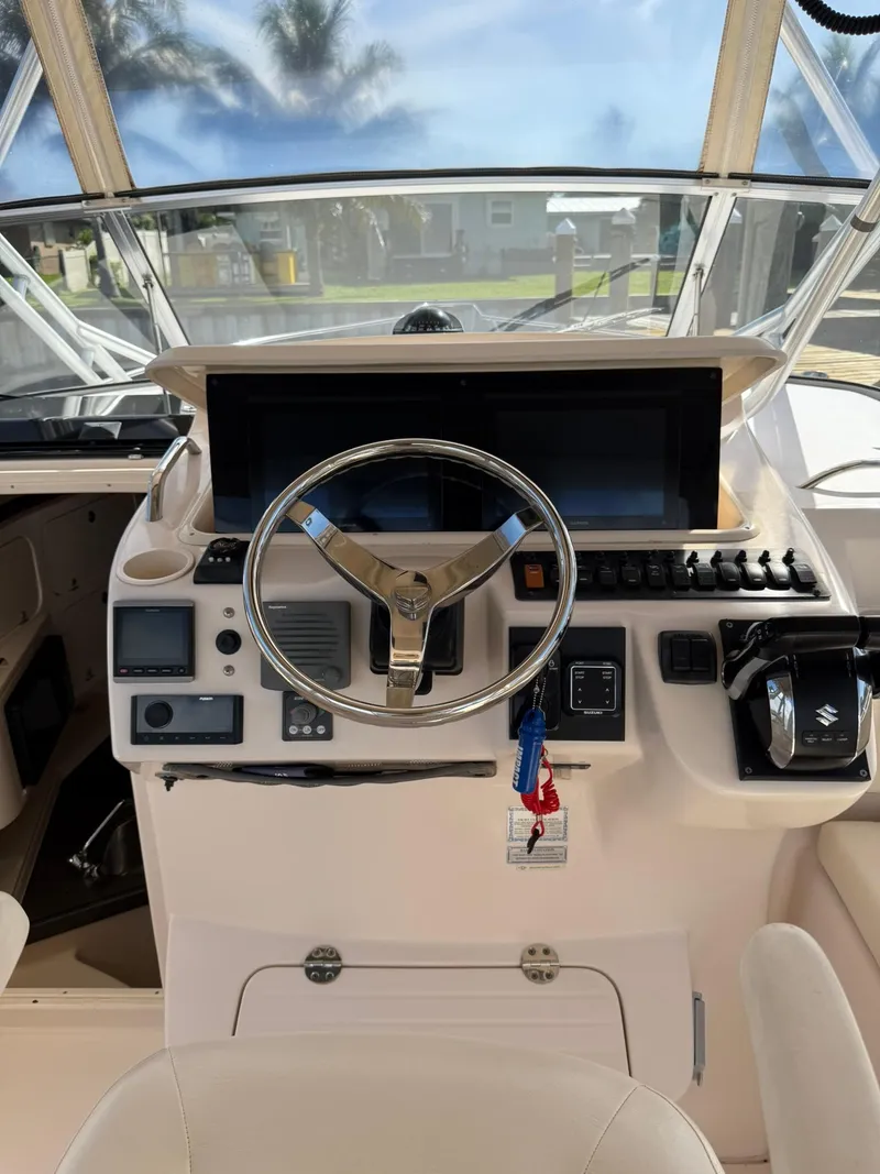 Slide: The Image of Helm of 2007 Grady-White Express 330 boat with steering wheel and navigation controls. - 41