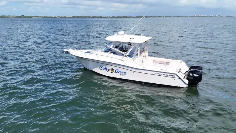 Slide: The Image of 2007 Grady-White Express 330 boat on open water, featuring Suzuki outboard engine. - 7