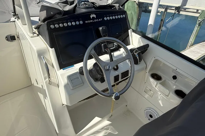 Slide: The Image of 2023 World Cat 280 DC-X boat helm with steering wheel and control panel. - 10