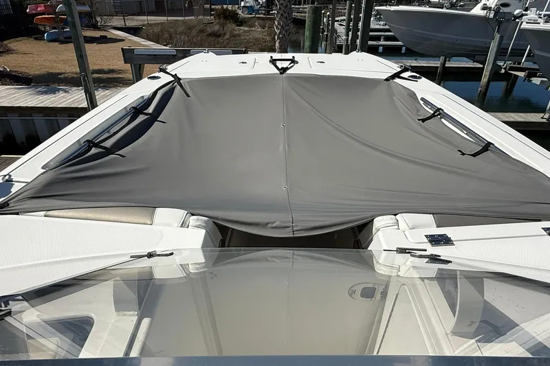 Slide: The Image of 2023 World Cat 280 DC-X boat with a gray cover at a marina. - 6