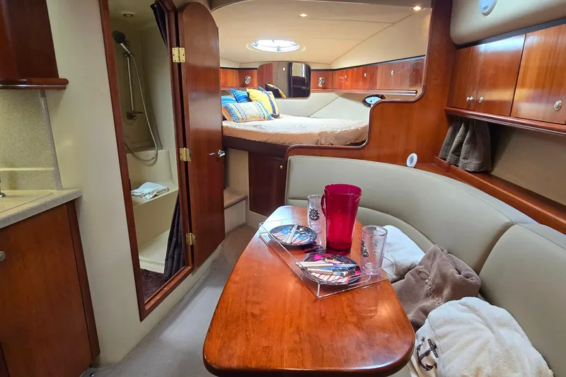 Slide: The Image of 2005 Cruisers Yachts 340 Express cabin interior with dining area, bed, and bathroom. - 17